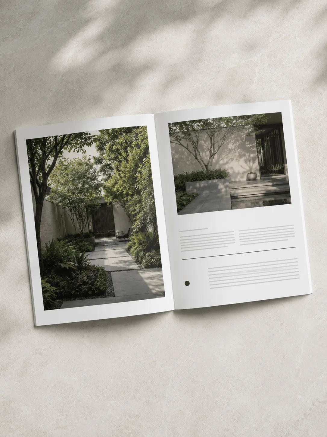 An open magazine showcasing architectural renders of minimalist courtyards with lush green gardens and stone pathways.
